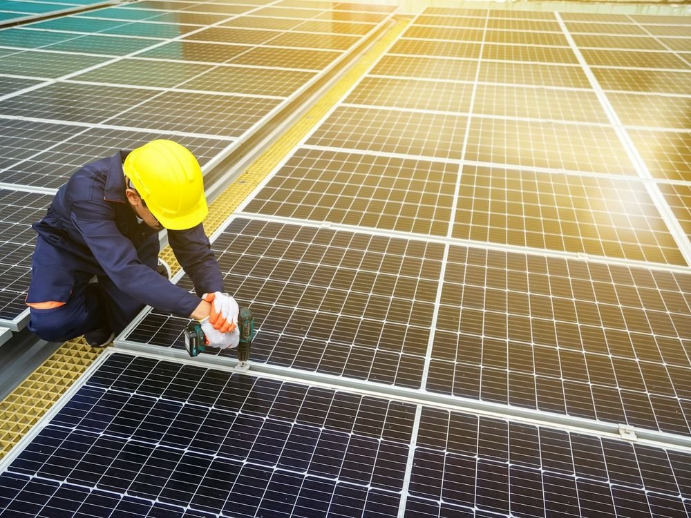 Engineer inspecting and cleaning a solar array